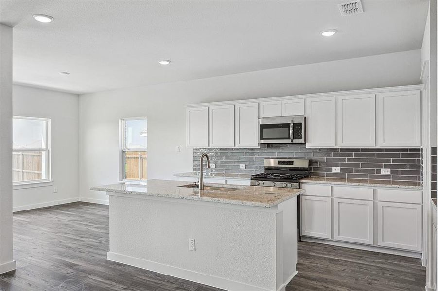 Kitchen with sink, stainless steel appliances, dark wood-type flooring, and white cabinets