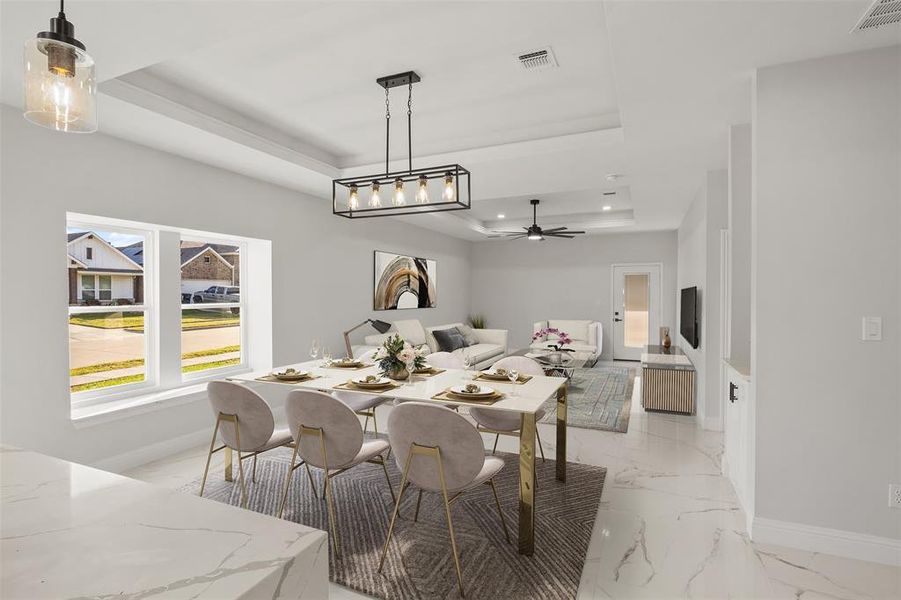 Dining area featuring a tray ceiling, light marble finish flooring, a ceiling fan, and recessed lighting