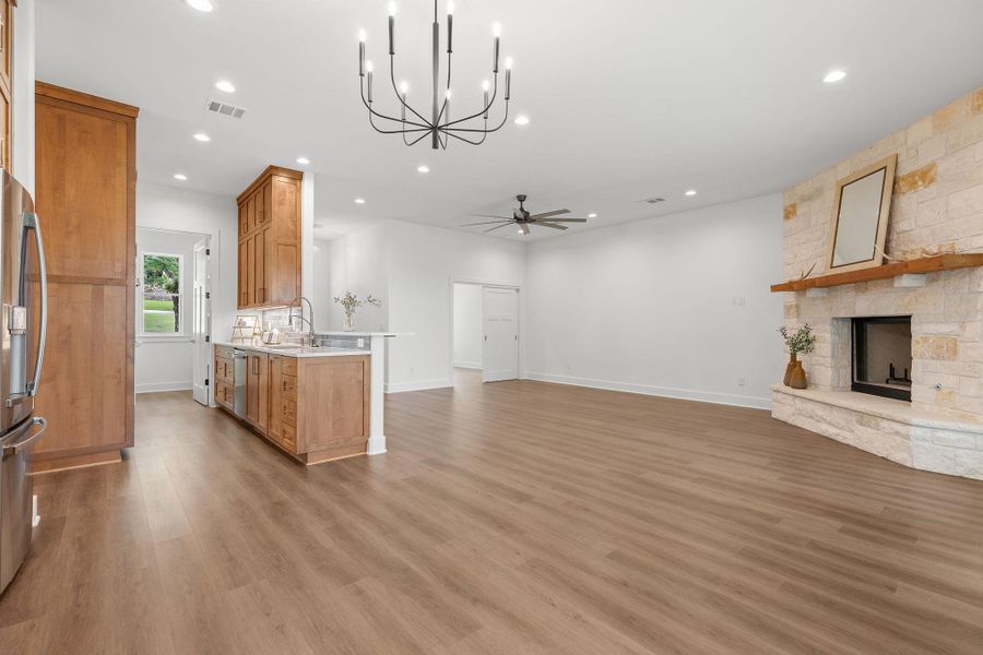 Kitchen featuring open floor plan, a fireplace, recessed lighting, light countertops, and ceiling fan Kitchen featuring open floor plan, a fireplace, recessed lighting, light countertops, and ceiling fan