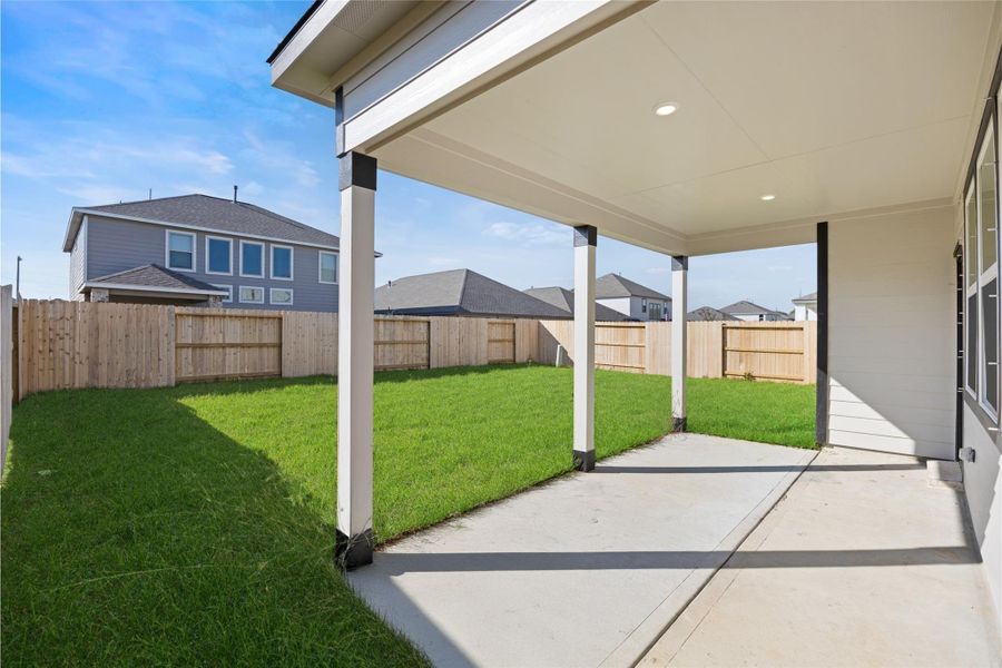 This photo showcases a covered patio with recessed lighting, overlooking a spacious fenced backyard with well-maintained grass. Ideal for outdoor relaxation and entertaining. This photo showcases a covered patio with recessed lighting, overlooking a spacious fenced backyard with well-maintained grass. Ideal for outdoor relaxation and entertaining.