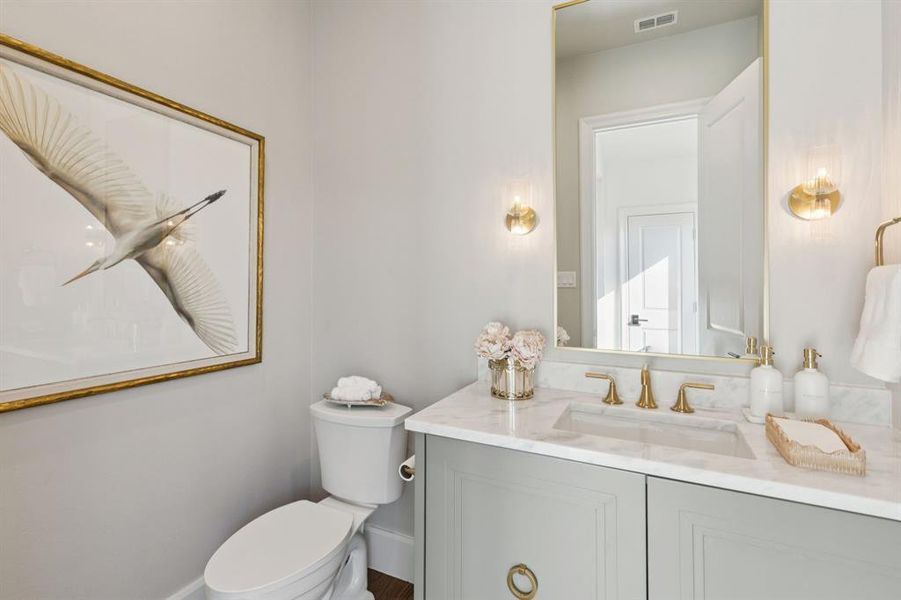 Half bathroom featuring toilet and vanity Half bathroom featuring toilet and vanity