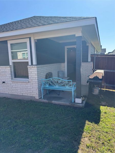Property entrance featuring brick siding and roof with shingles
