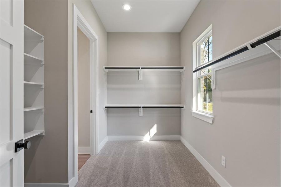 Primary Closet includes a window, built ins and plenty of hanging spaces.