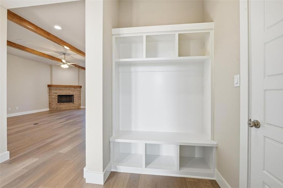 Mudroom featuring a fireplace, wood finished floors, a ceiling fan, recessed lighting, and beamed ceiling