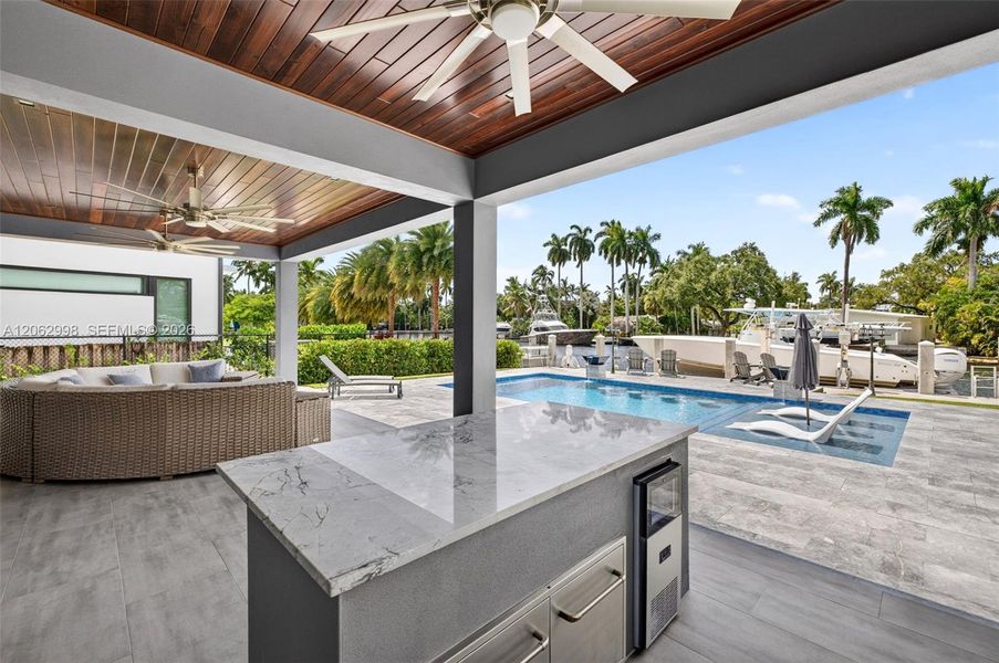 Covered patio w/ T&G ceilings, fans, fire pit seating and outdoor kitchen overlooks the gorgeous wide New River views and pool area