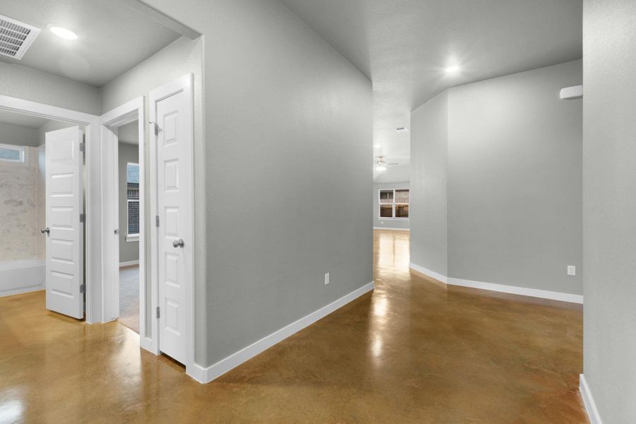 Clean lines and a luminous polished floor lead the way through this bright, welcoming hallway.