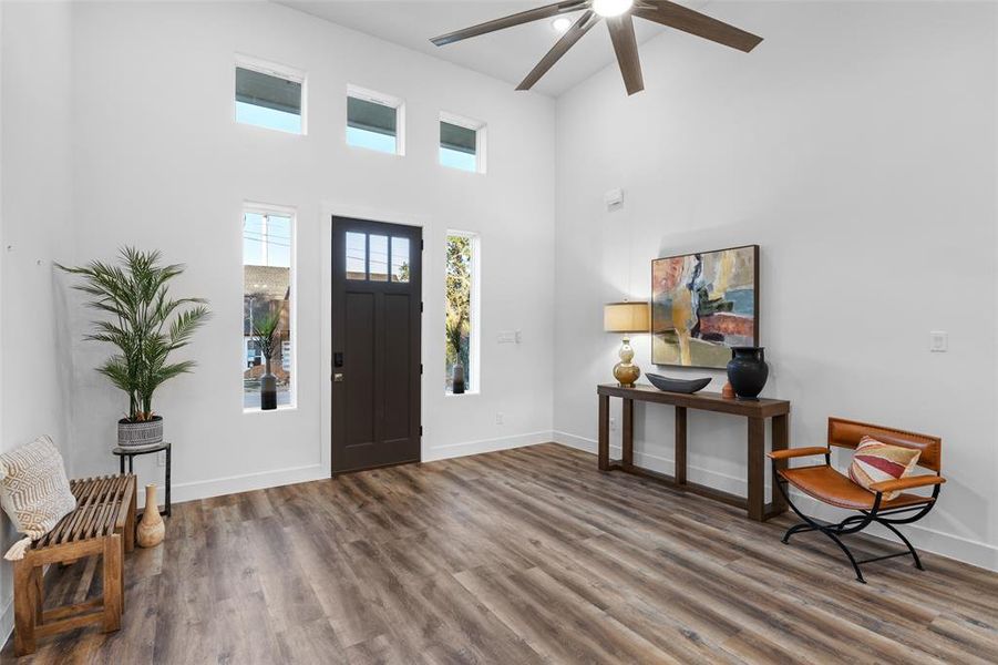 Foyer entrance with a high ceiling, hardwood / wood-style floors, and ceiling fan