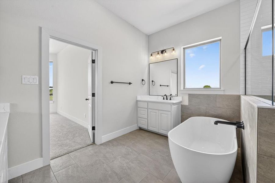 Full bath with vanity, a freestanding tub, light tile patterned flooring, and a walk in shower