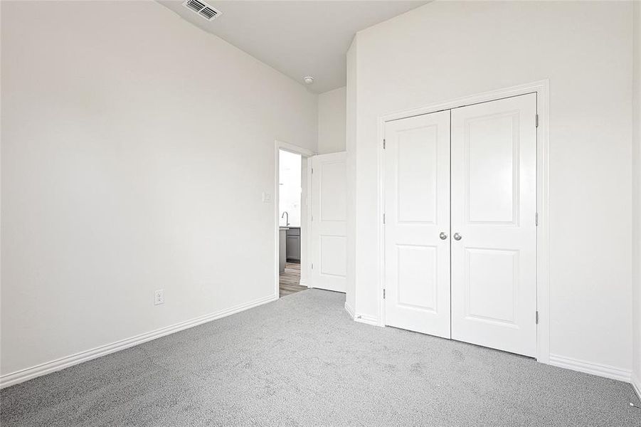 Unfurnished bedroom featuring carpet floors and a closet Unfurnished bedroom featuring carpet floors and a closet