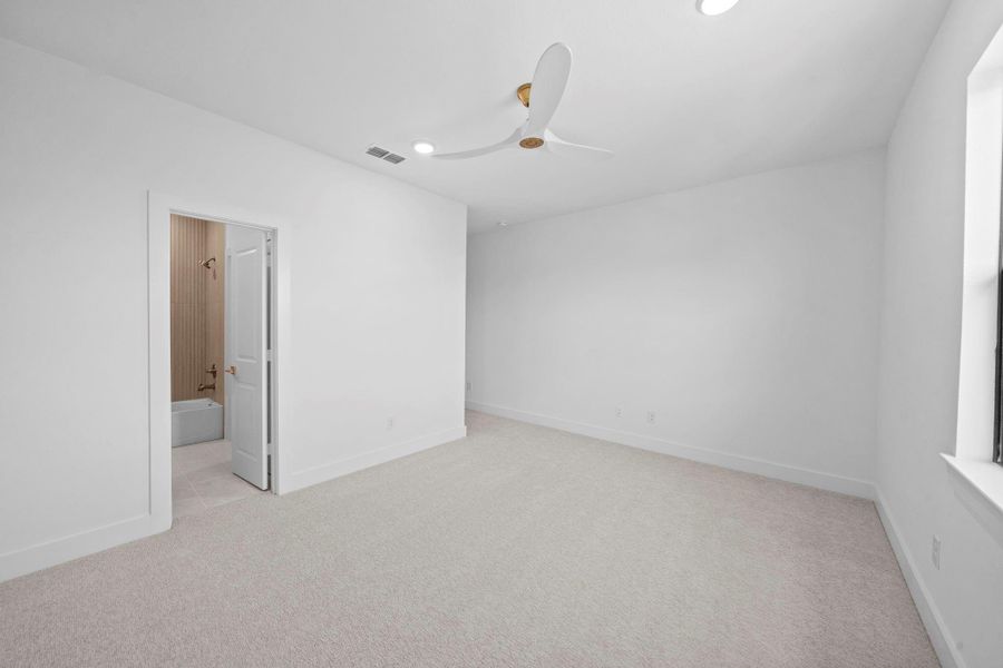 Bright secondary bedroom offering generous space and a peaceful atmosphere.