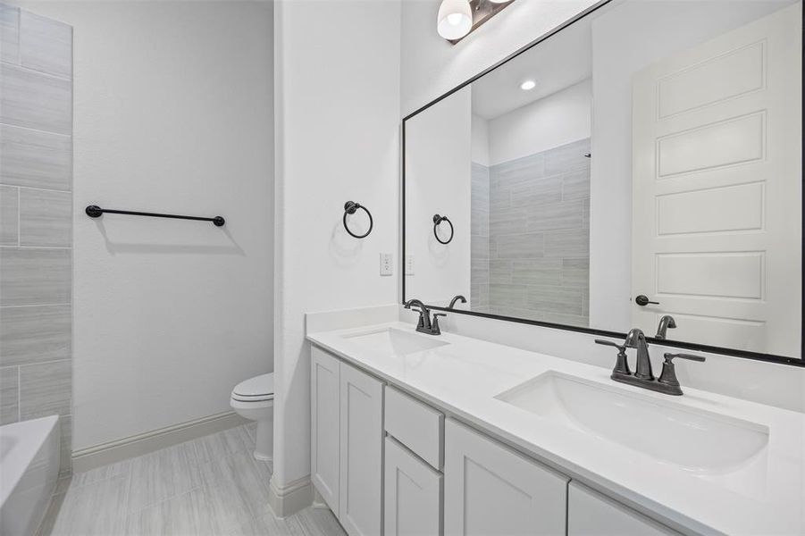 Bathroom featuring toilet and double vanity Bathroom featuring toilet and double vanity