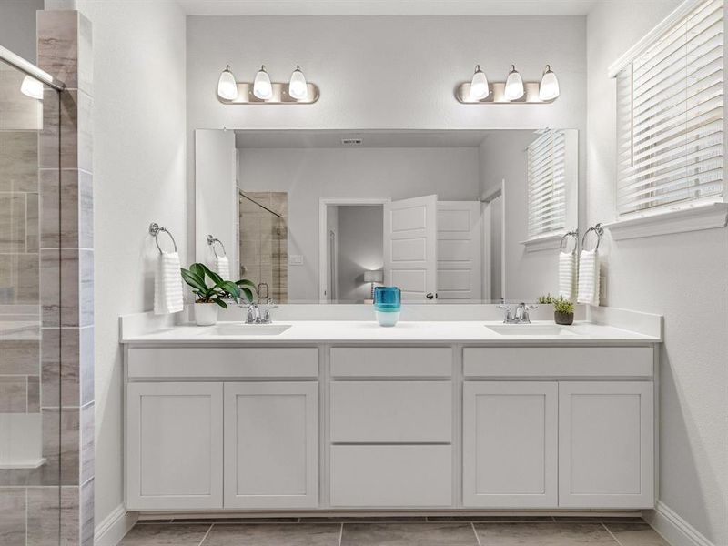 Spa-like ensuite bathroom showcases elegant dual vanities, modern hardware, and extensive storage cabinets.