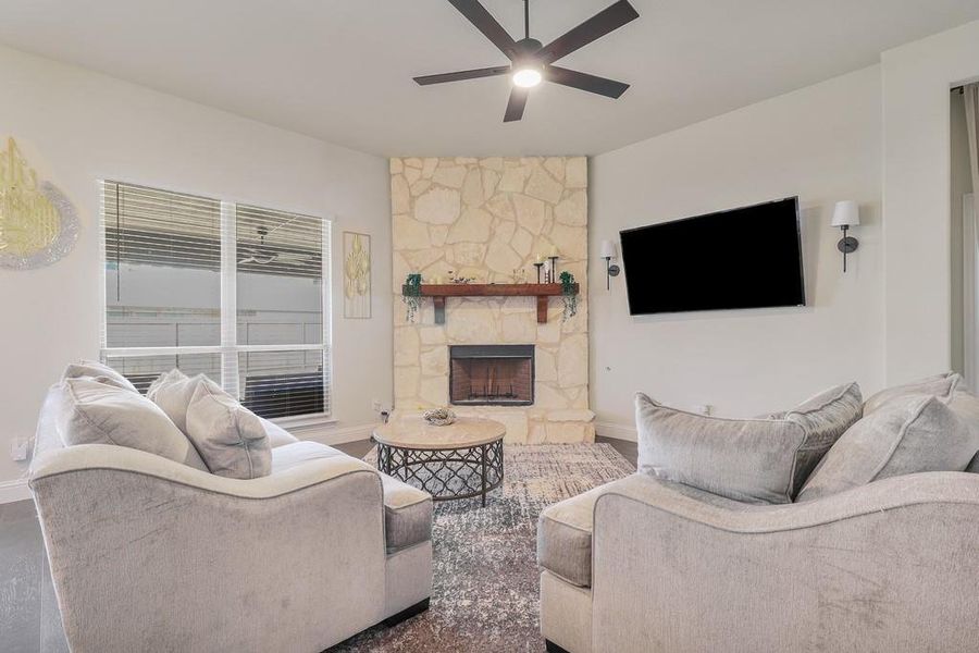 Living room featuring ceiling fan and a fireplace