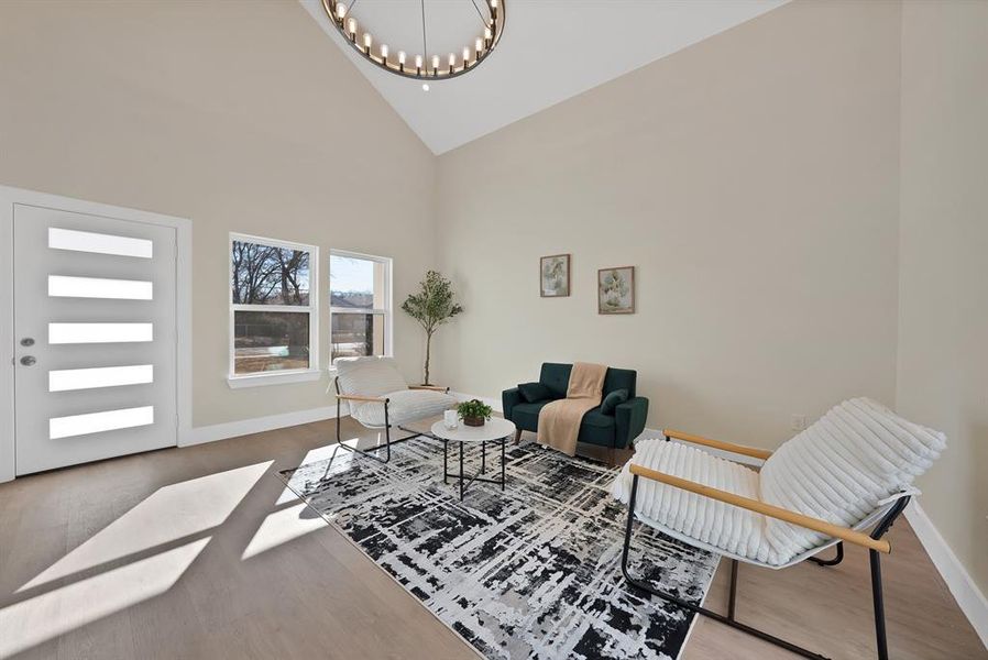 Living room featuring high vaulted ceiling, a chandelier, and light wood-type flooring