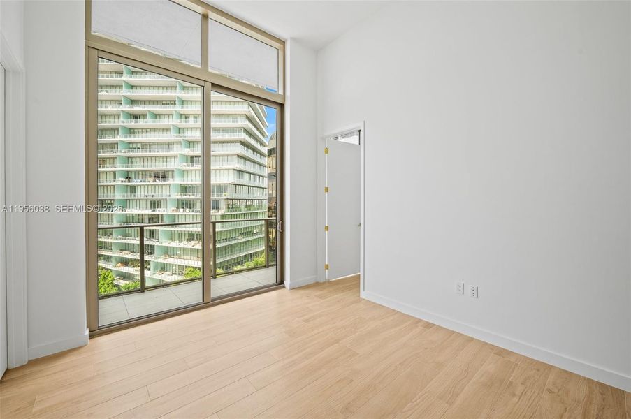 Bright and airy Master bedroom with floor-to-ceiling windows, high ceilings, and abundant natural light in this luxury Coconut Grove residence.