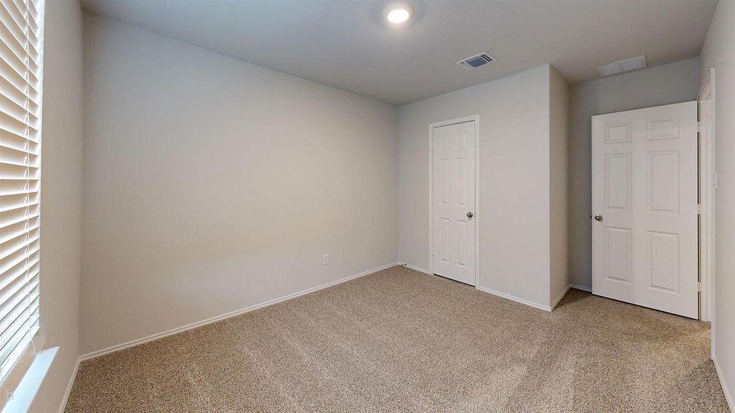 Unfurnished bedroom featuring light carpet and baseboards