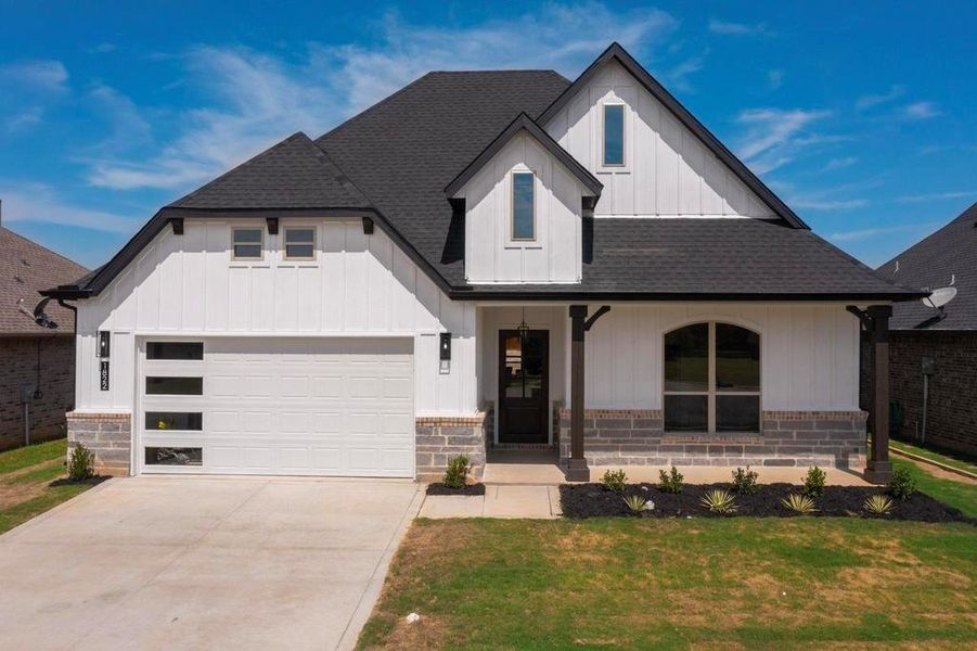 Modern inspired farmhouse featuring roof with shingles, board and batten siding, driveway, a front lawn, and a porch