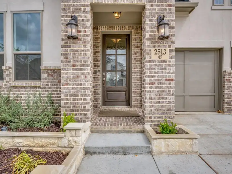 Property entrance with brick siding and a garage