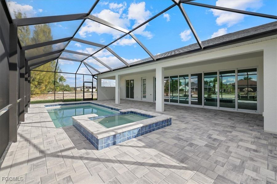 View of pool with a sunroom, a patio area, a pool with connected hot tub, and a lanai