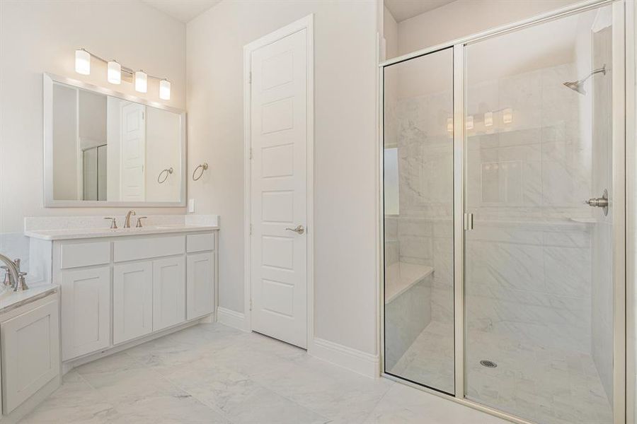 Bathroom with a stall shower, vanity, and light marble finish floors Bathroom with a stall shower, vanity, and light marble finish floors