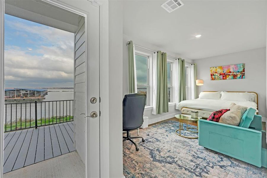 Bedroom with a water view, light wood-style floors, and recessed lighting