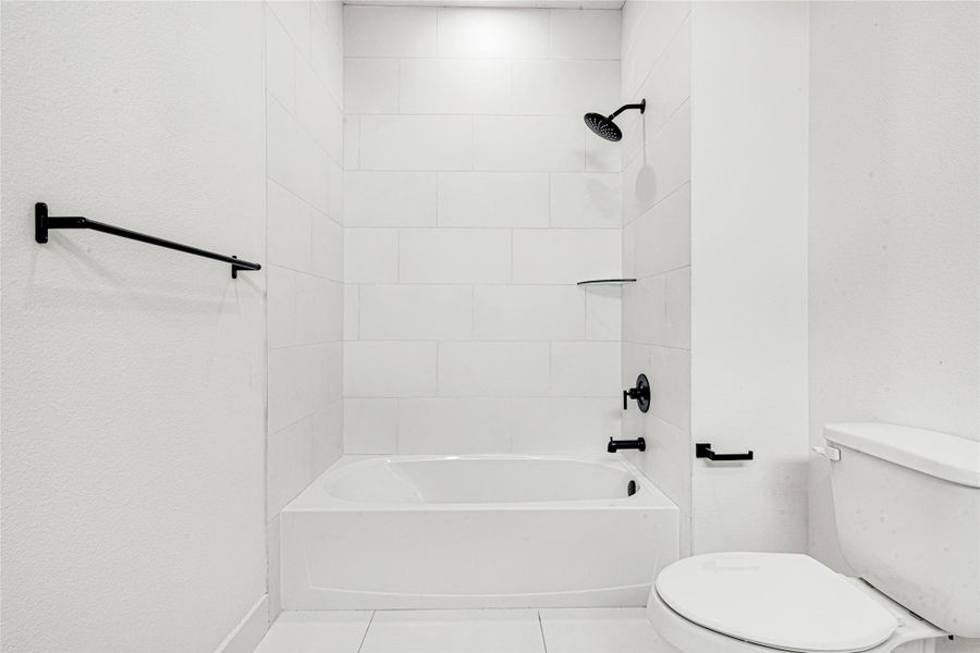 This view of the secondary Jack and Jill bathroom showcases the black and white modern look shown throughout the house.