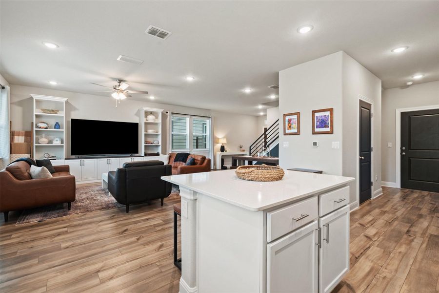 Kitchen featuring ceiling fan, white cabinets, visible vents, a kitchen island, and light wood finished floors