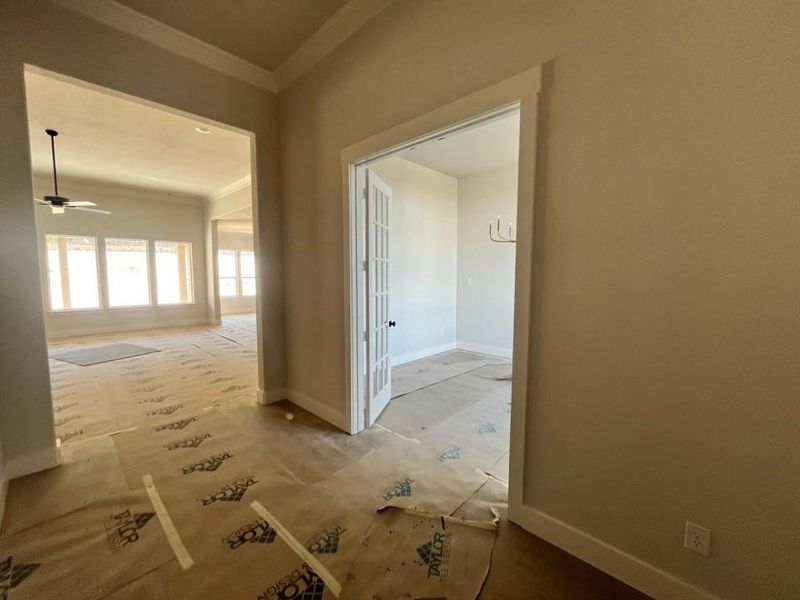 Hallway featuring crown molding and baseboards