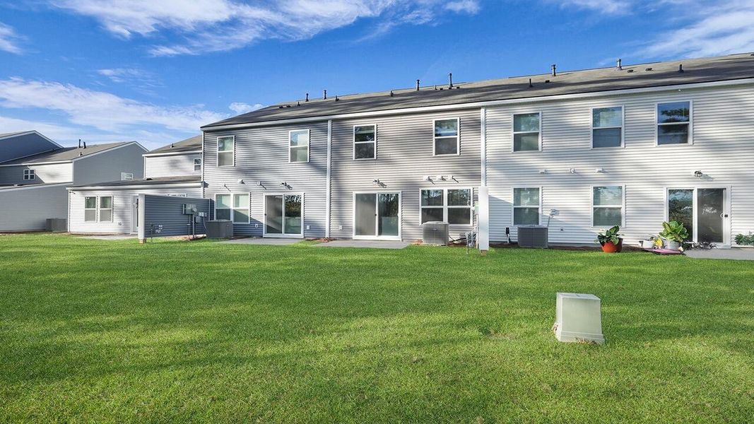 Exterior details and patio area of a home in Pine Hills Townhomes at Cane Bay, Summerville (Image 3).