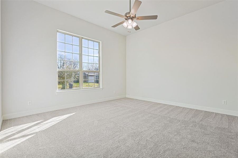 Empty room featuring light carpet and ceiling fan