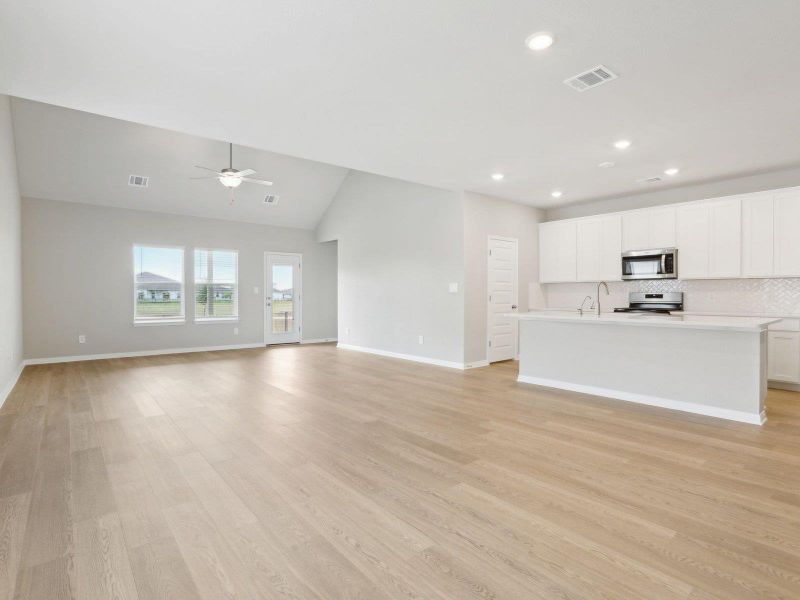 Unfurnished living room featuring a ceiling fan, recessed lighting, baseboards, light wood-type flooring, and vaulted ceiling Unfurnished living room featuring a ceiling fan, recessed lighting, baseboards, light wood-type flooring, and vaulted ceiling