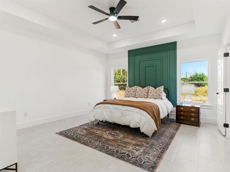 Bedroom with a raised ceiling, a ceiling fan, and recessed lighting