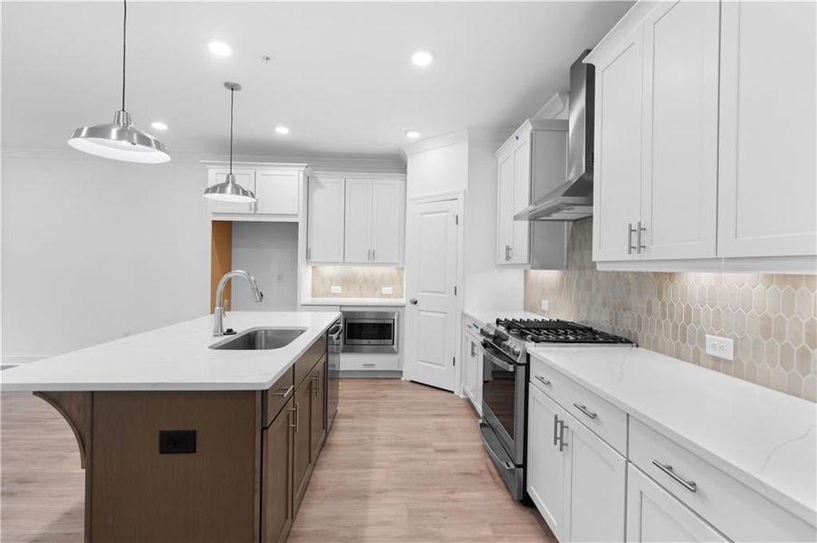 A natural-stained island adds warmth and contrast, serving as both a functional centerpiece and a stylish focal point while the picket-style backsplash brings a subtle geometric texture.