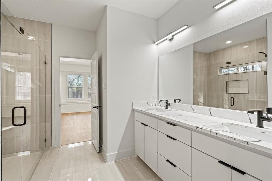 Bathroom featuring double vanity, a sink, and a shower stall