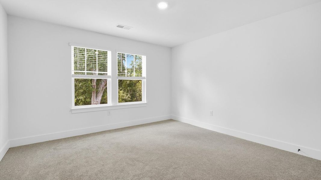 Bright and serene bedroom with comfortable carpeted flooring and large windows for vibrant light by DRB Homes Bright and serene bedroom with comfortable carpeted flooring and large windows for vibrant light by DRB Homes