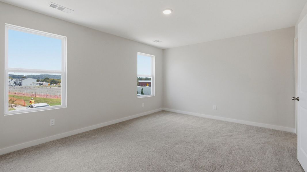 Spacious primary bedroom with connected bathroom and walk-in shower