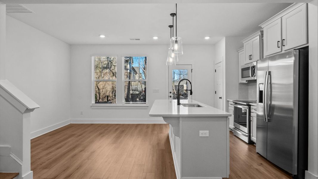 Memorable moments begin in this elegant, open family room with hardwood flooring and refined finishes in Arden, NC