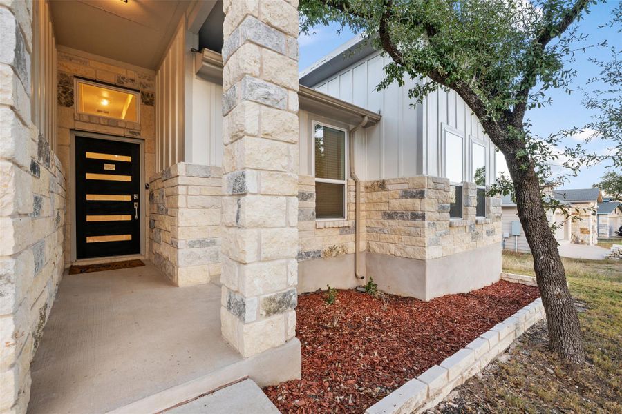 Entrance to property featuring board and batten siding and stone siding Entrance to property featuring board and batten siding and stone siding