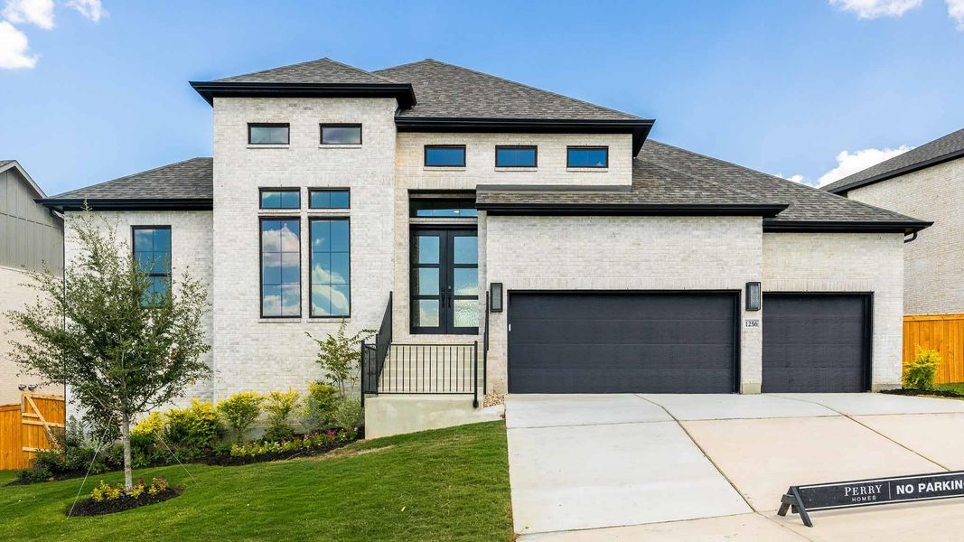 View of front facade featuring a shingled roof, brick siding, driveway, and an attached garage View of front facade featuring a shingled roof, brick siding, driveway, and an attached garage