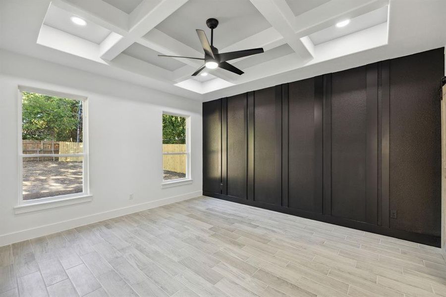 Spare room featuring ceiling fan, coffered ceiling, and light hardwood / wood-style flooring