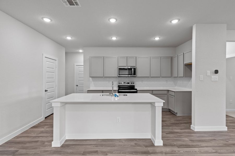A kitchen with white cabinets.
