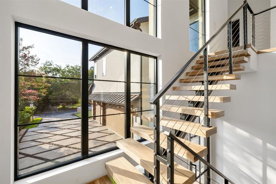 Floating wood-finish staircase with cable railing system