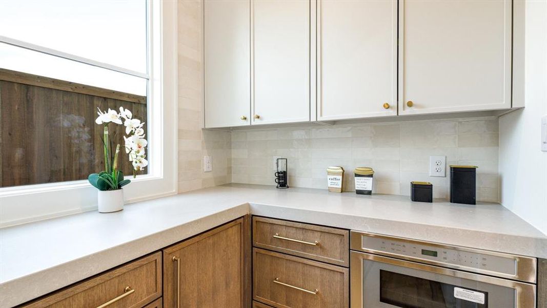 Kitchen featuring white cabinetry, tasteful backsplash, and stainless steel oven