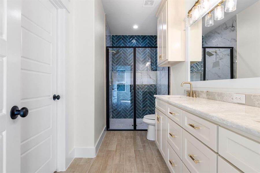 Bathroom featuring hardwood / wood-style flooring, vanity, toilet, and walk in shower