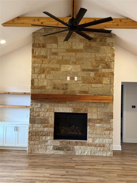 Floor to ceiling stone fireplace, with a remotely controlled gas fireplace.  Sold cedar mantle and floating shelves on the side cabinetry.  52" ceiling fan descending from cedar beams on the vaulted ceiling.