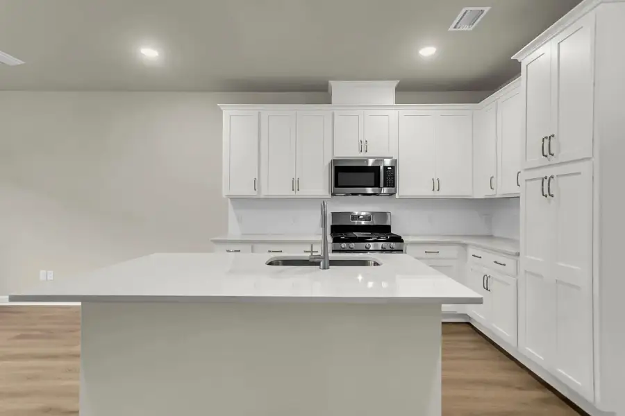 White cabinets, stainless appliances, and oversized island create timeless style.