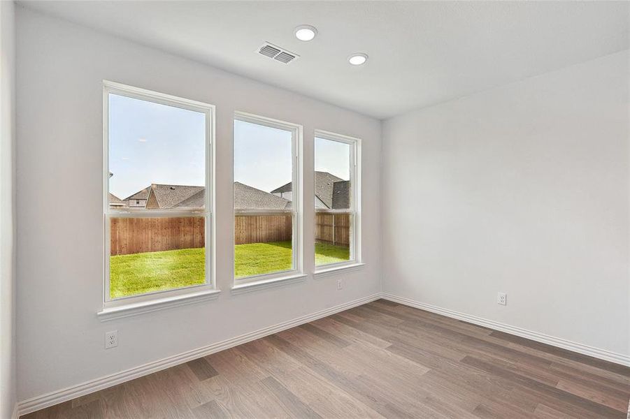 Unfurnished room featuring hardwood / wood-style flooring and plenty of natural light