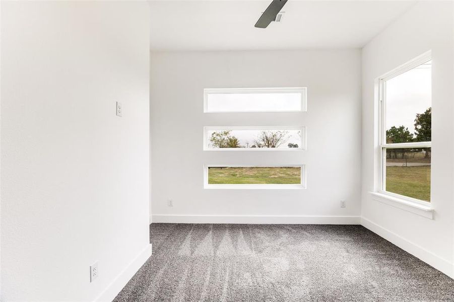 Carpeted spare room featuring baseboards and a ceiling fan Carpeted spare room featuring baseboards and a ceiling fan