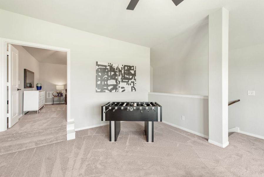 Bonus room with foosball table, carpet flooring, vaulted ceiling, and ceiling fan