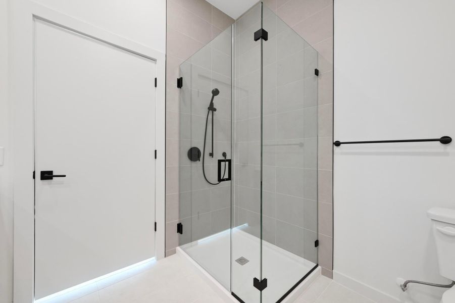 Bathroom featuring a shower stall and toilet Bathroom featuring a shower stall and toilet